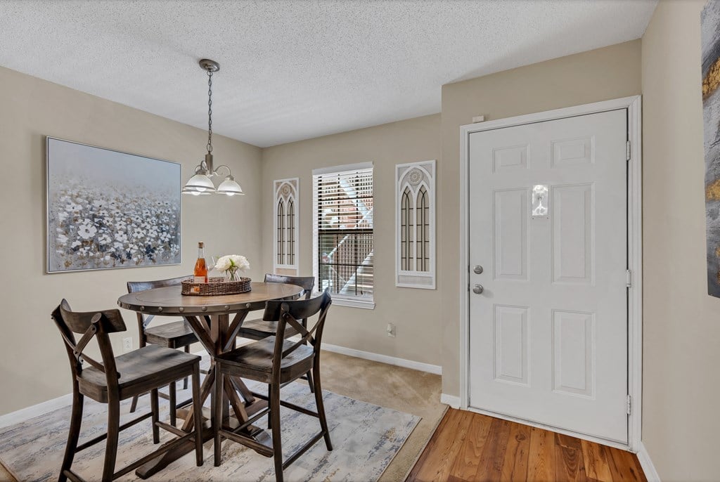 a dining room with a table and chairs and a white door